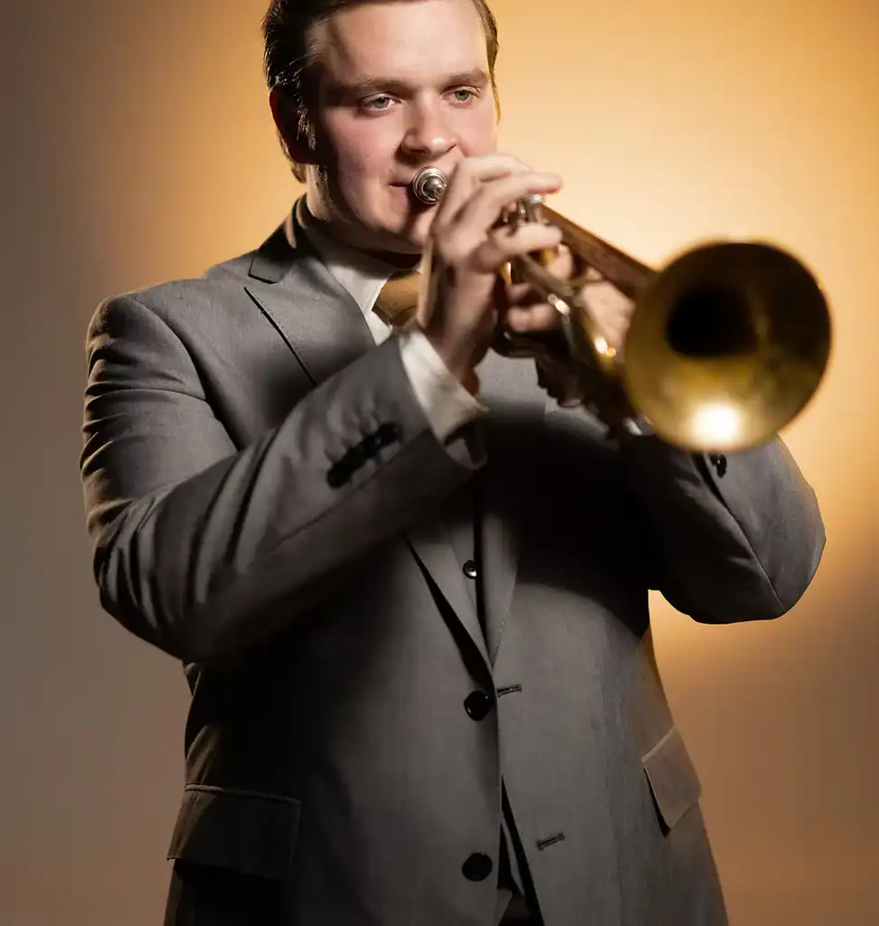 A man in a gray suit plays trumpet, ideal for wedding entertainment in Minnesota or Wisconsin events.