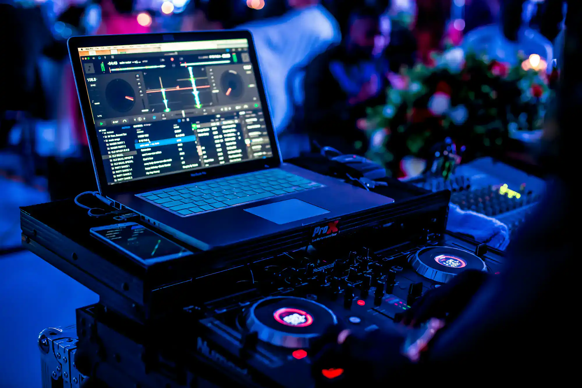 A DJ controller and laptop with mixing software set up at a lively party by a top wedding DJ in Minnesota.
