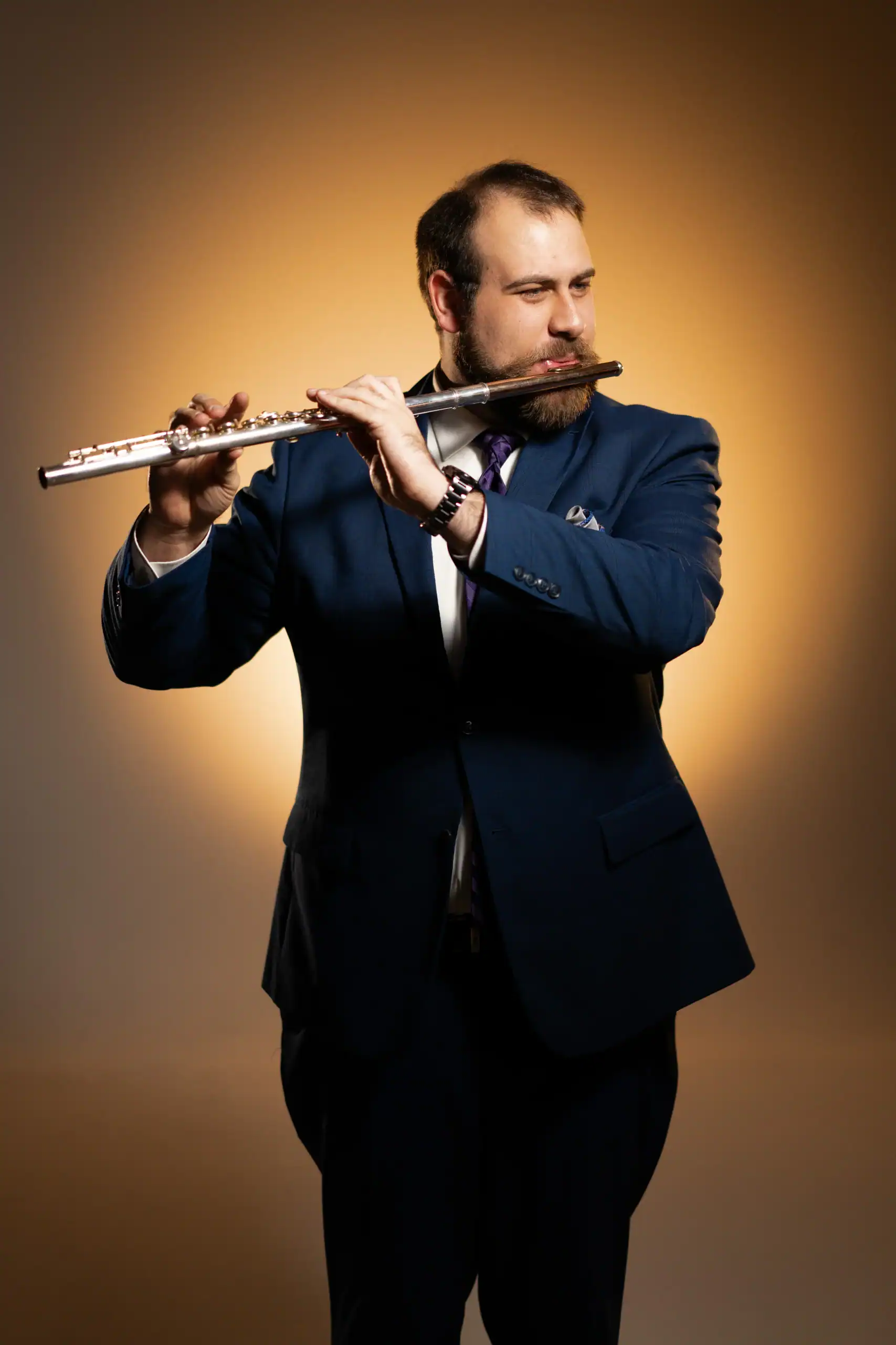 A man in a blue suit plays the flute, ideal for wedding entertainment at Minnesota or Wisconsin events.